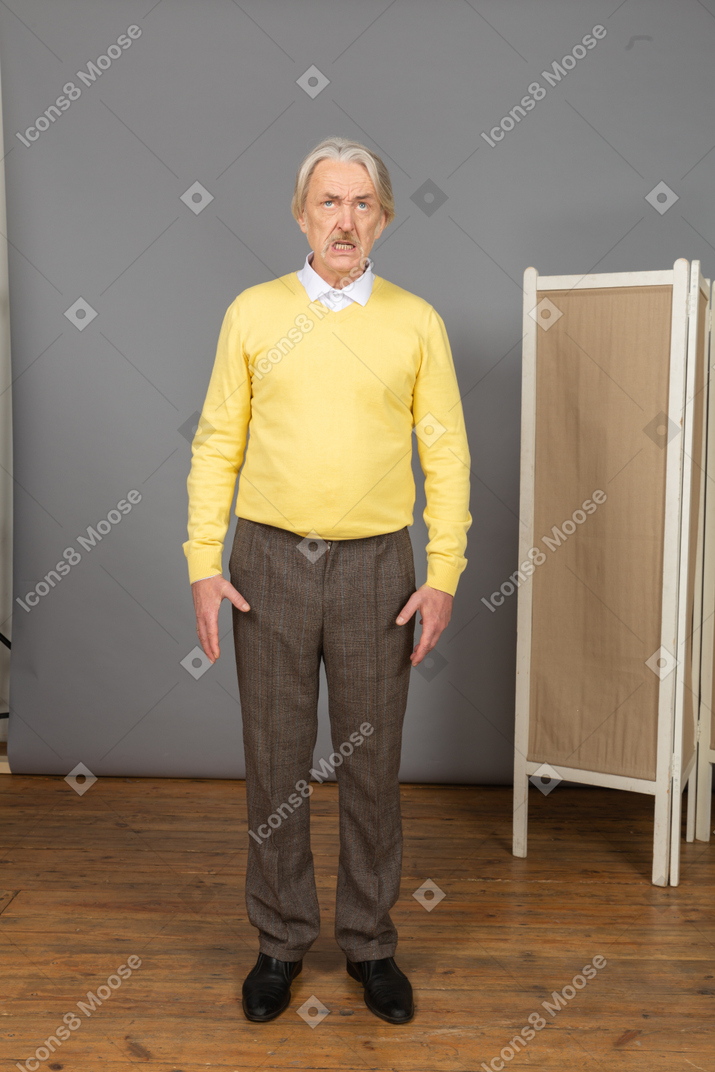 Front view of an impatient old man clenching teeth while looking up