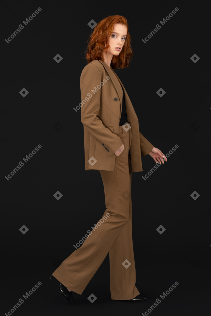 A woman in a brown suit and black shoes