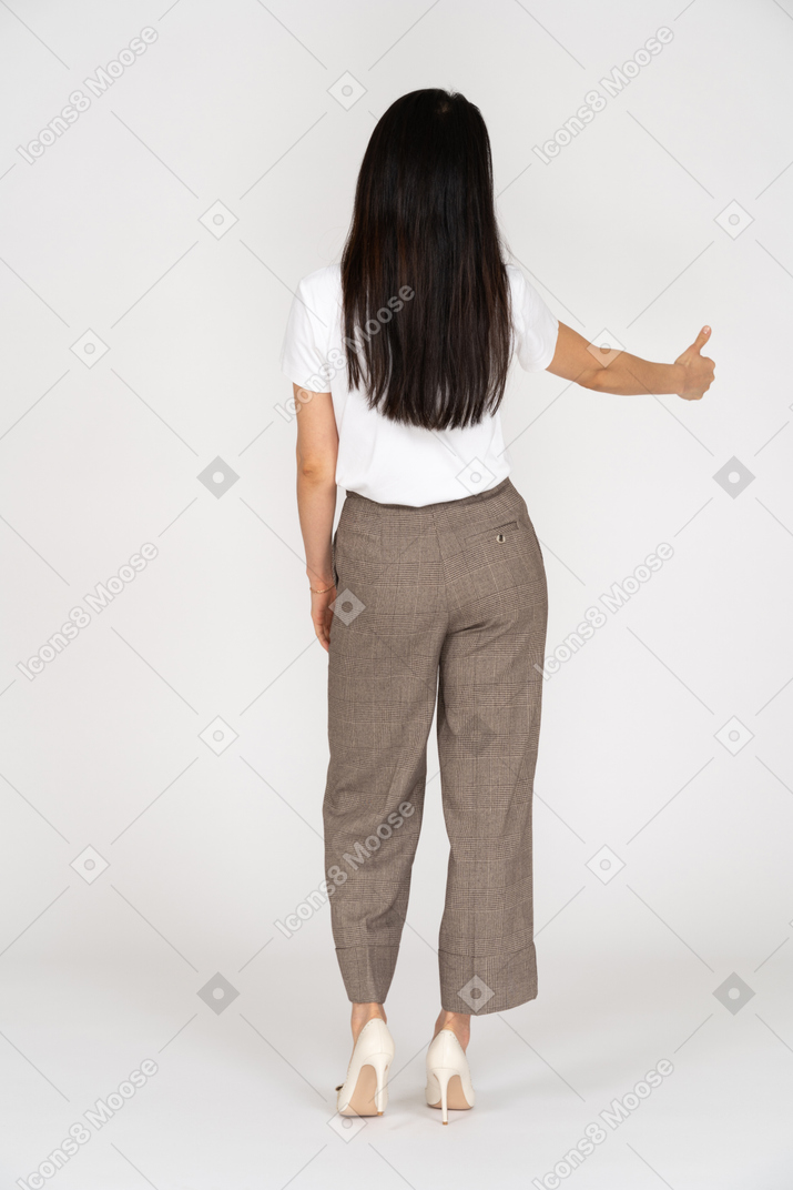 Back view of a young lady in breeches and t-shirt showing thumb up