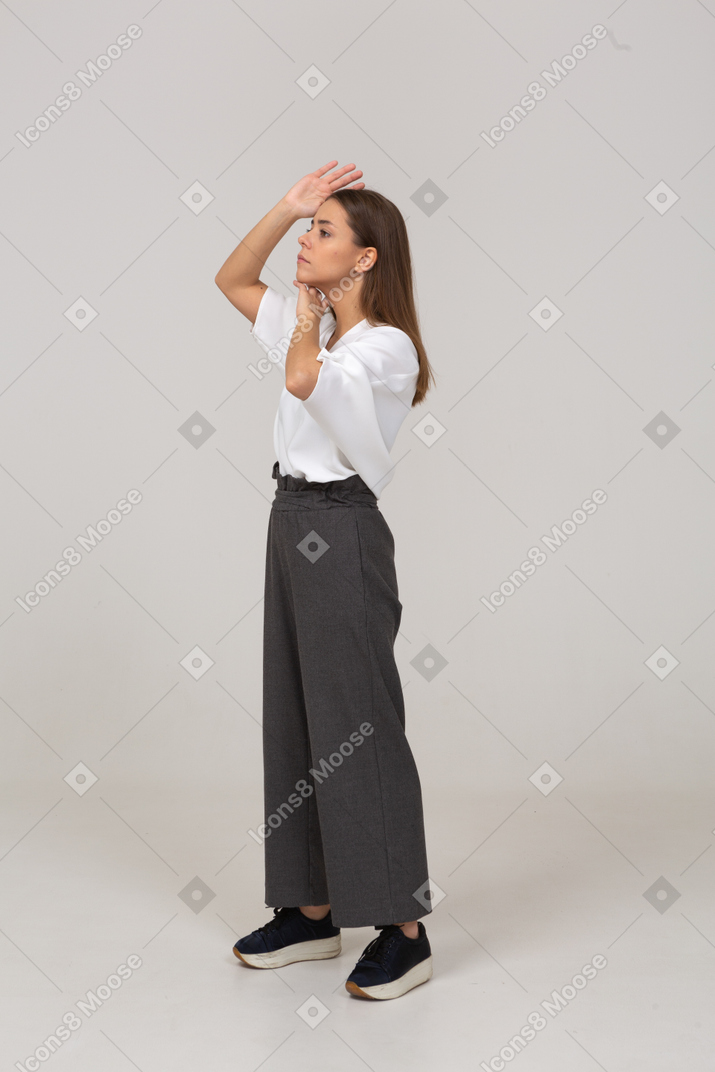Three-quarter view of a young lady in office clothing touching her face