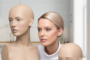 A woman posing with two mannequins