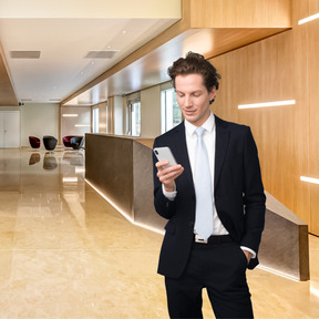 A man in a suit looking at a cell phone
