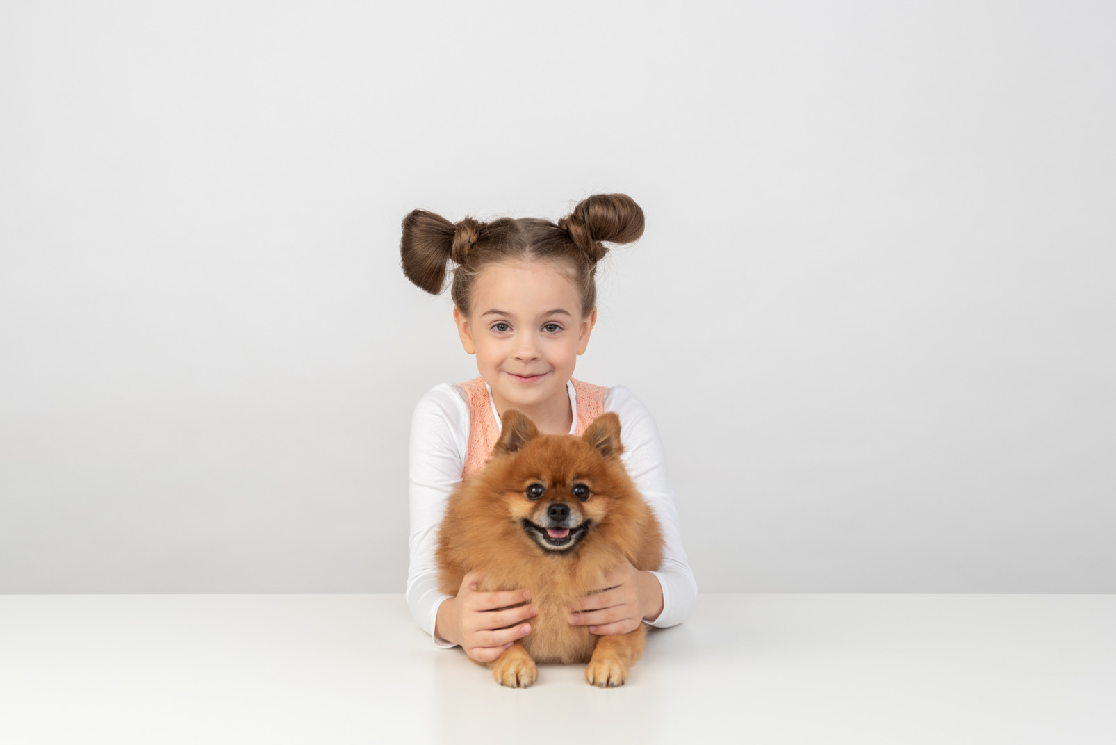 Kid girl holding spitz dog