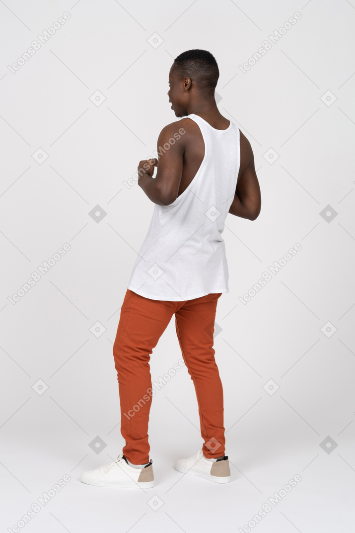 Rear view of black man standing with his elbows bent