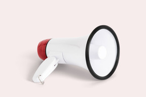 A white and red megaphone on a pink background
