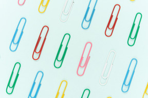 Colourful paper clips on blue background