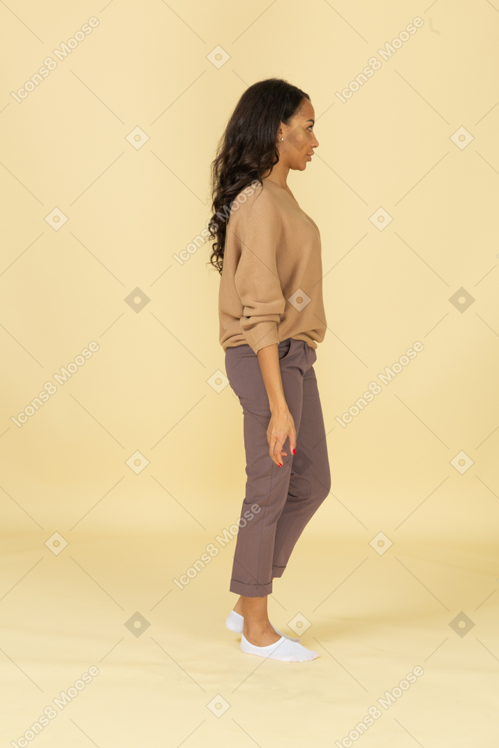 Vista lateral de una mujer joven interrogante de piel oscura