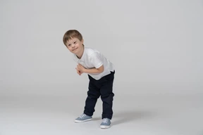 Cheerful little boy bending forward
