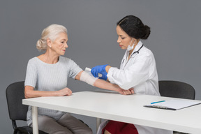 Femme médecin, mettre un pansement sur le coude du patient