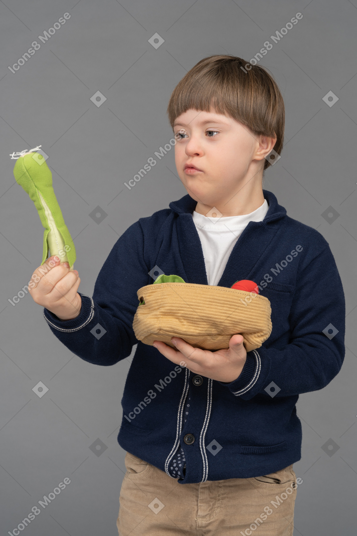 Little boy holding stuffed leek toy