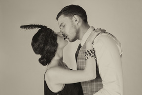 Well-dressed man and woman kissing and hugging