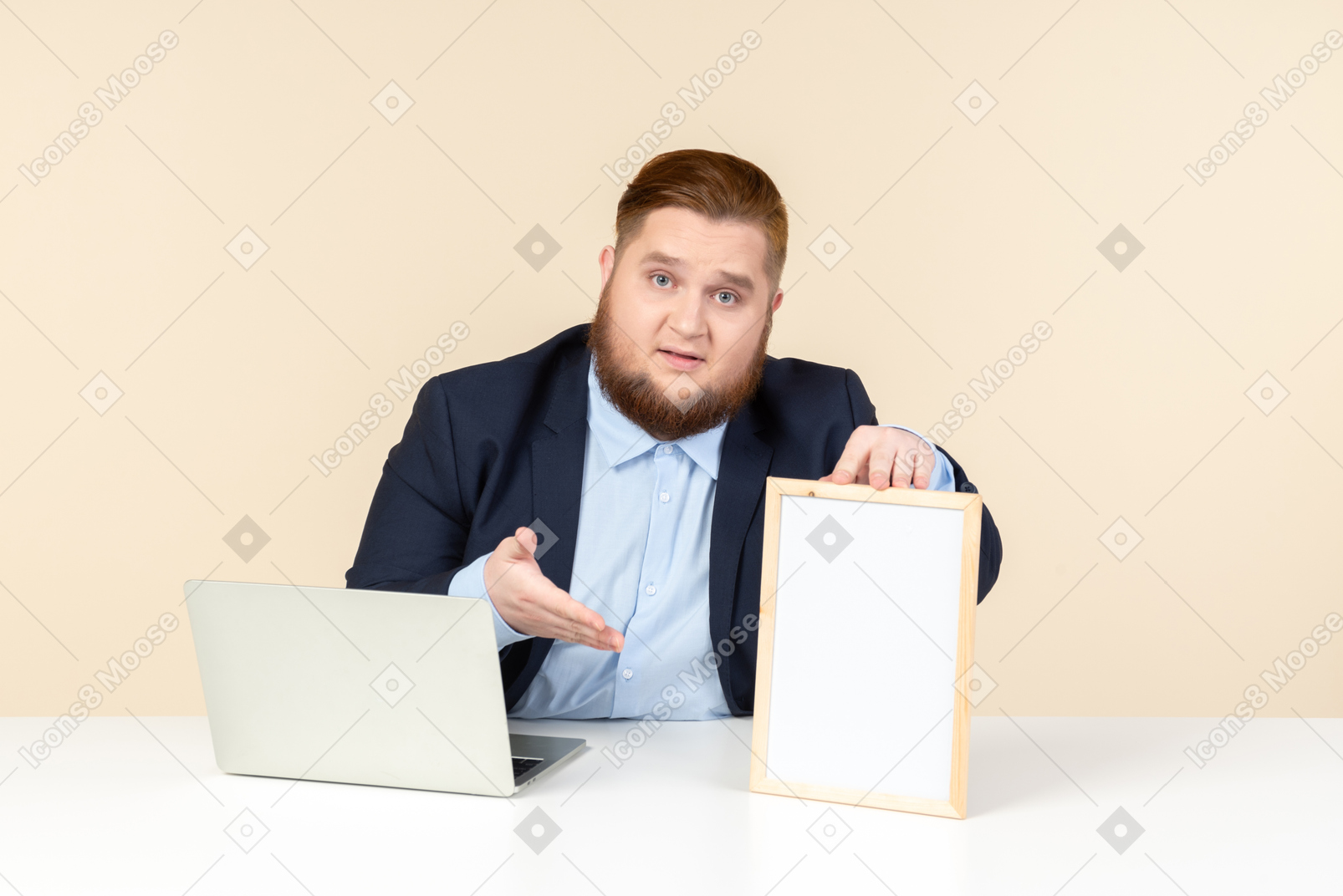 坐在膝上型计算机前面和指向图片的年轻超重人
