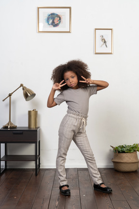 Good looking girl kid posing on the apartment background