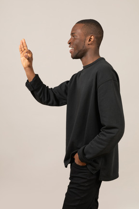 Vista laterale dell'uomo di colore che mostra un gesto ok