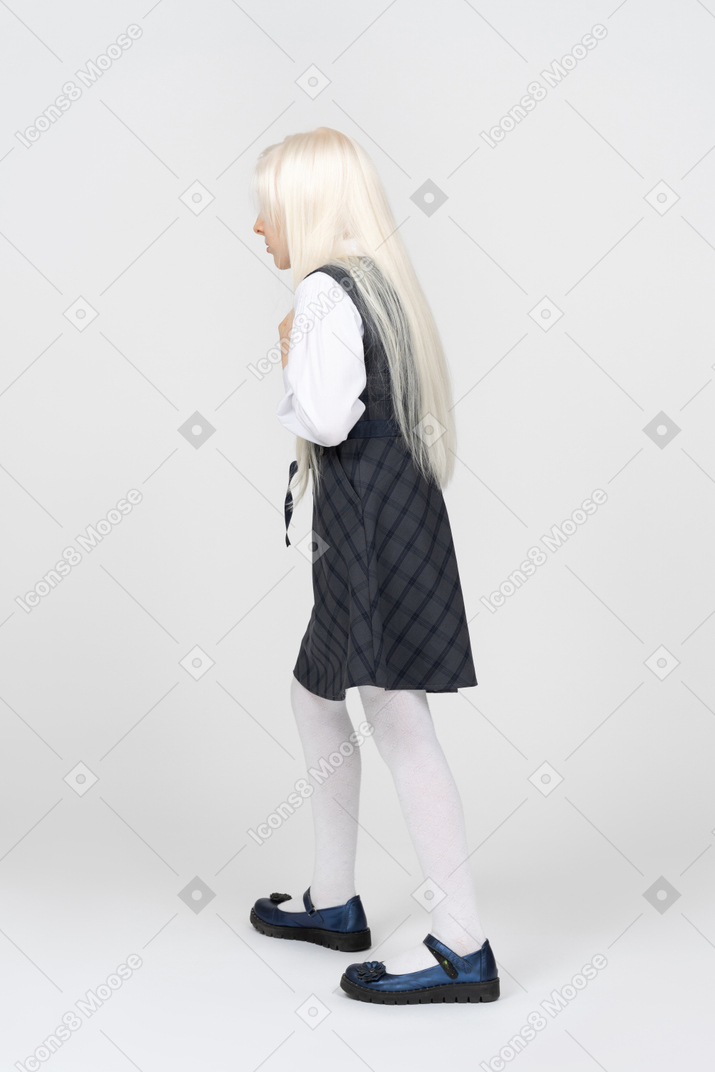 Side view of a schoolgirl walking cautiously