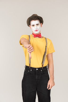 Sad looking male clown showing thumb down