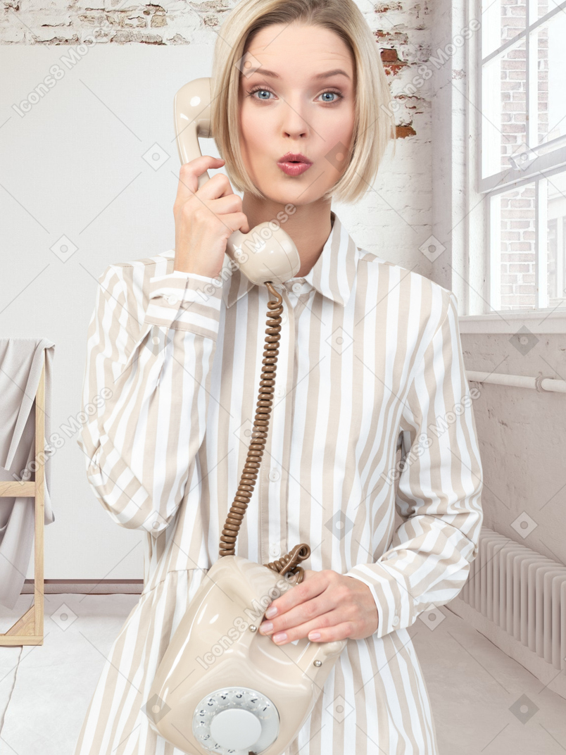 Surprised woman talking on a rotary phone