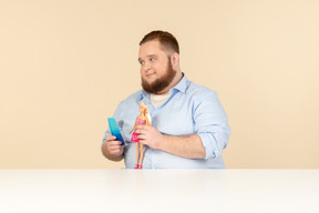 Big man holding hair brush and barbie doll