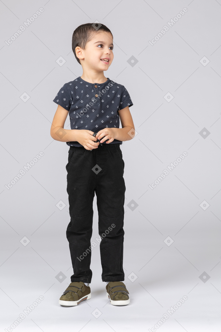 Vista frontale di un ragazzo felice in abiti casual che guarda in alto