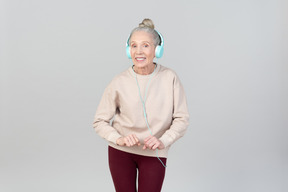 Joyful young lady in headphones dancing to music