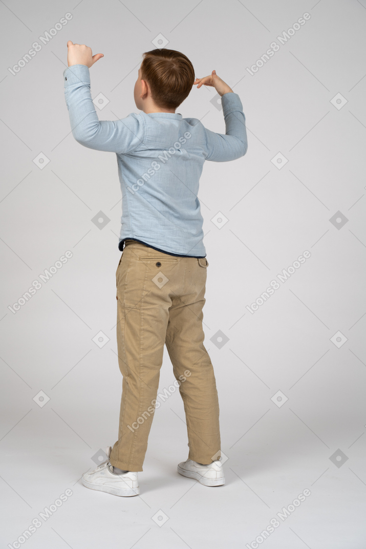 Vista traseira de um menino com o braço para cima