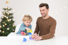 A man and a child playing with toys