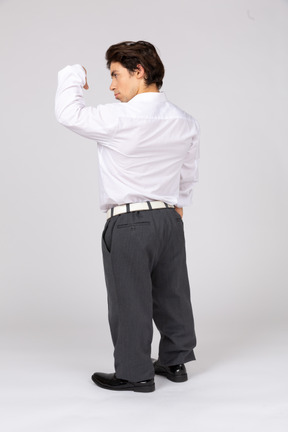 Back view of an office worker flexing arm muscles
