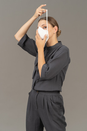 人工呼吸器を装着するグレーのカバーオールを着た女性