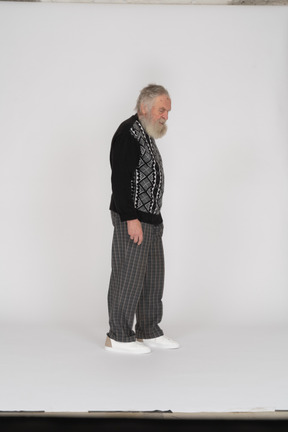 Side view of an elderly man standing and looking down