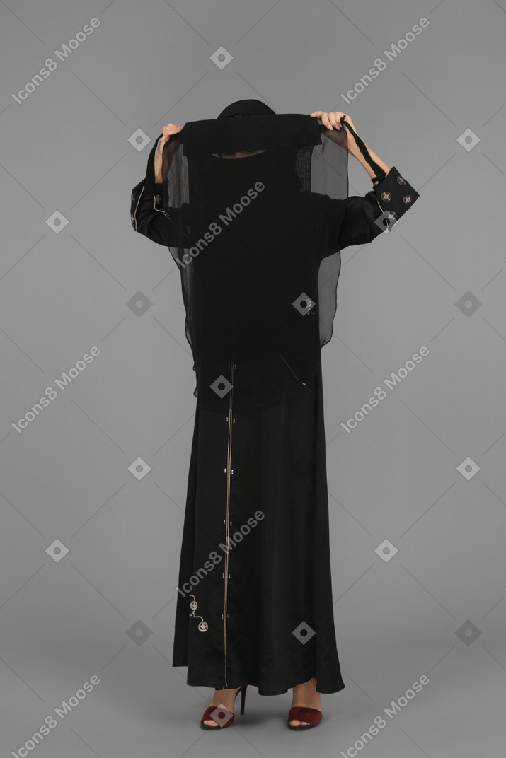 Uma mulher muçulmana colocando um niqab