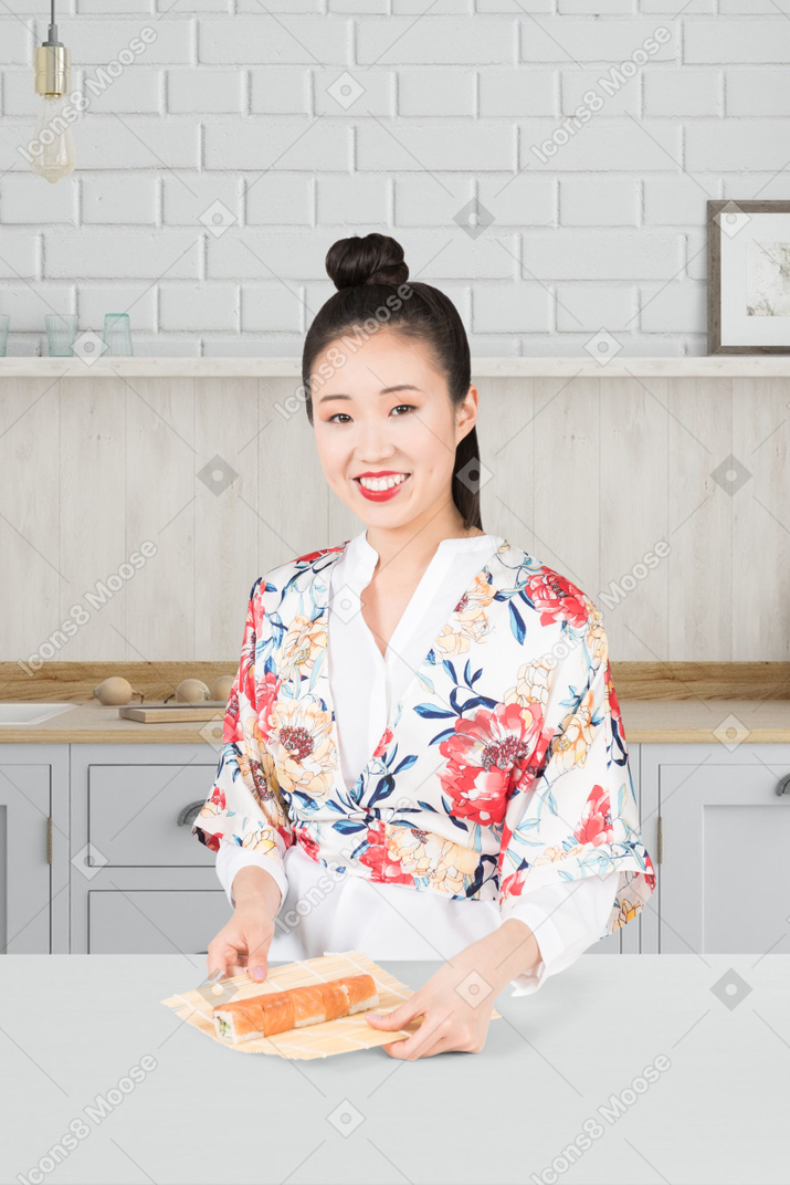 Frau im kimono bereitet sushi zu