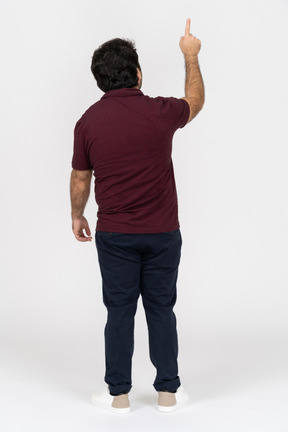 Back view of a man in casual clothes pointing