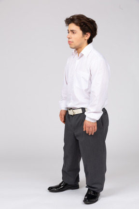 Вид в три четверти на мужчину в деловой повседневной одежде, смотрящего в сторону