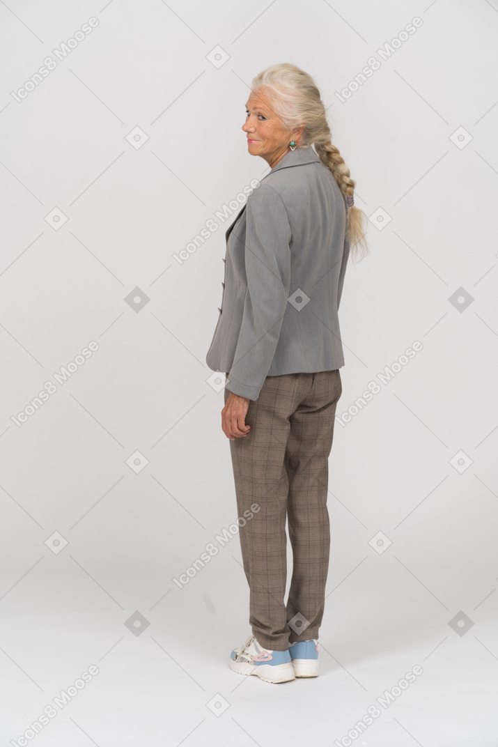 一位身穿灰色夹克的老太太的后视图