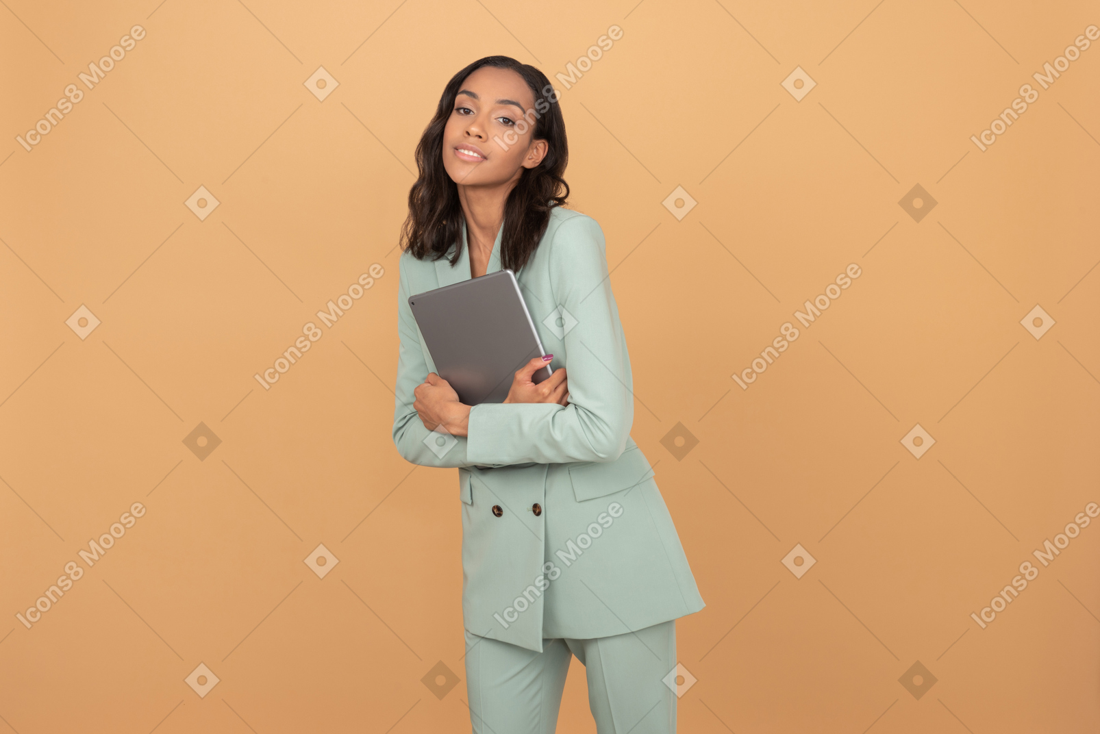 Beautiful office worker holding tablet close to her and looking to the camera like dreaming
