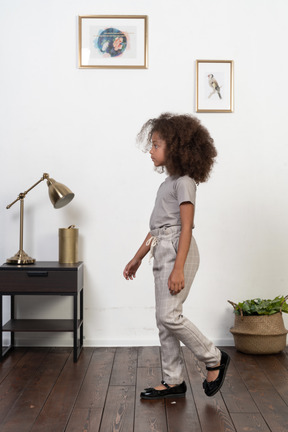 Good looking girl kid posing on the apartment background