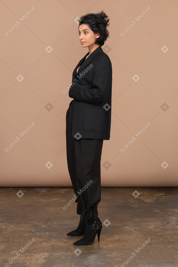 Vista de três quartos de uma mulher de negócios em um terno preto