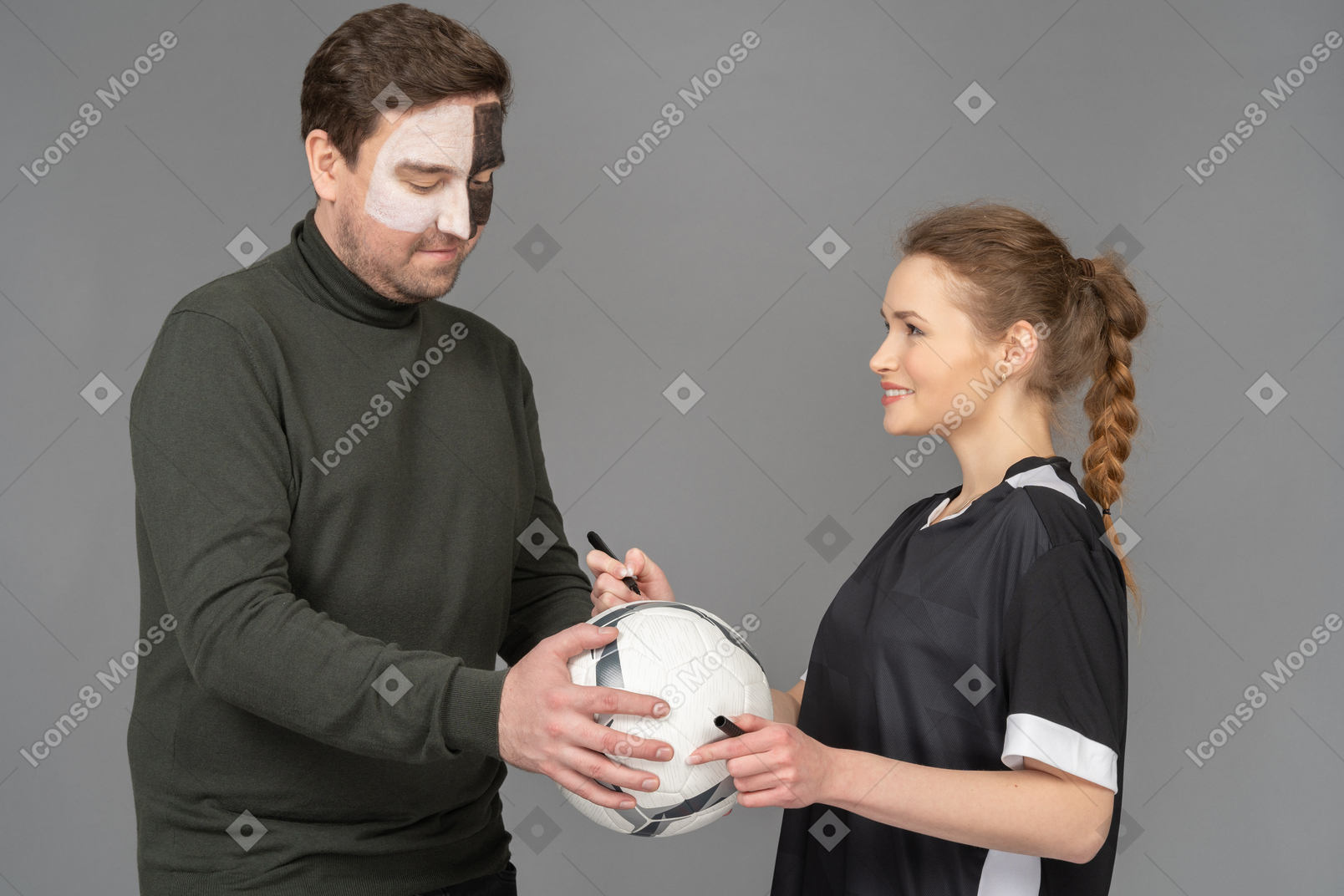 Female football player signing a ball for the fan
