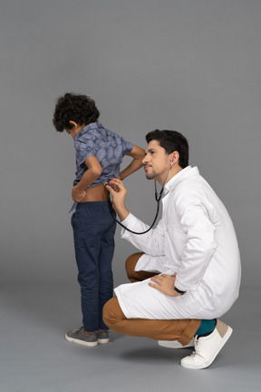 Doctor examinando a su pequeño paciente