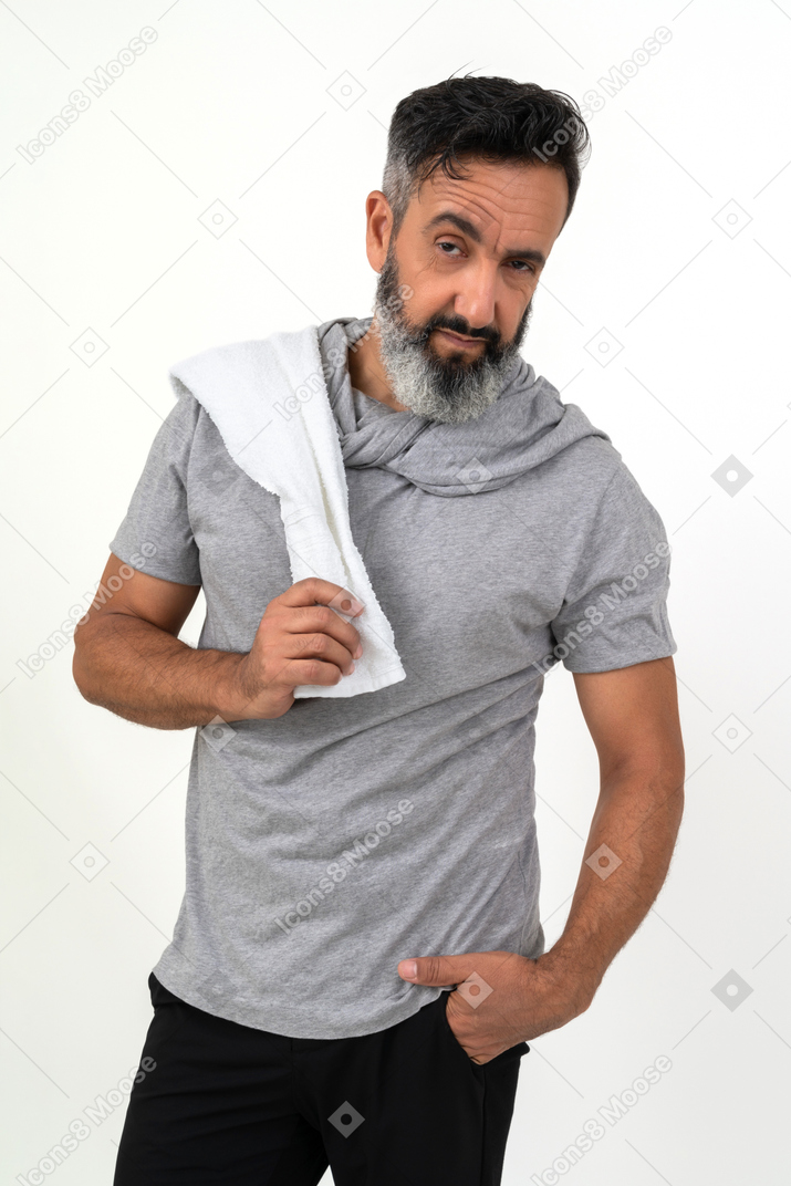 Mature man in sportive wear holding towel on his shoulder 