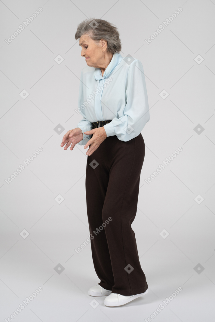 Three-quarter view of a shrugging and gesturing old lady