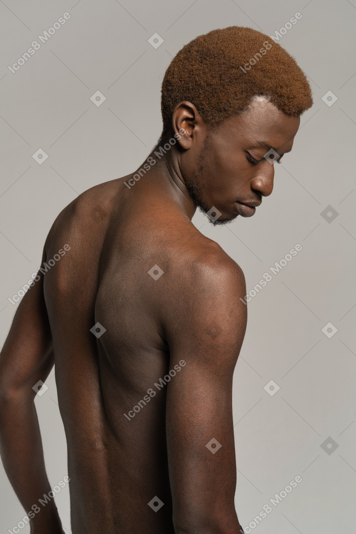 Ritratto di giovane uomo in topless che guarda in basso