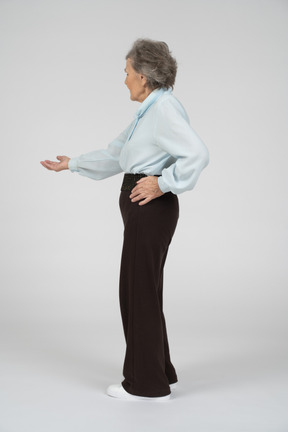 Side view of an old woman stretching out her hand