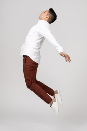 Side view of a young latino man stretching in the air