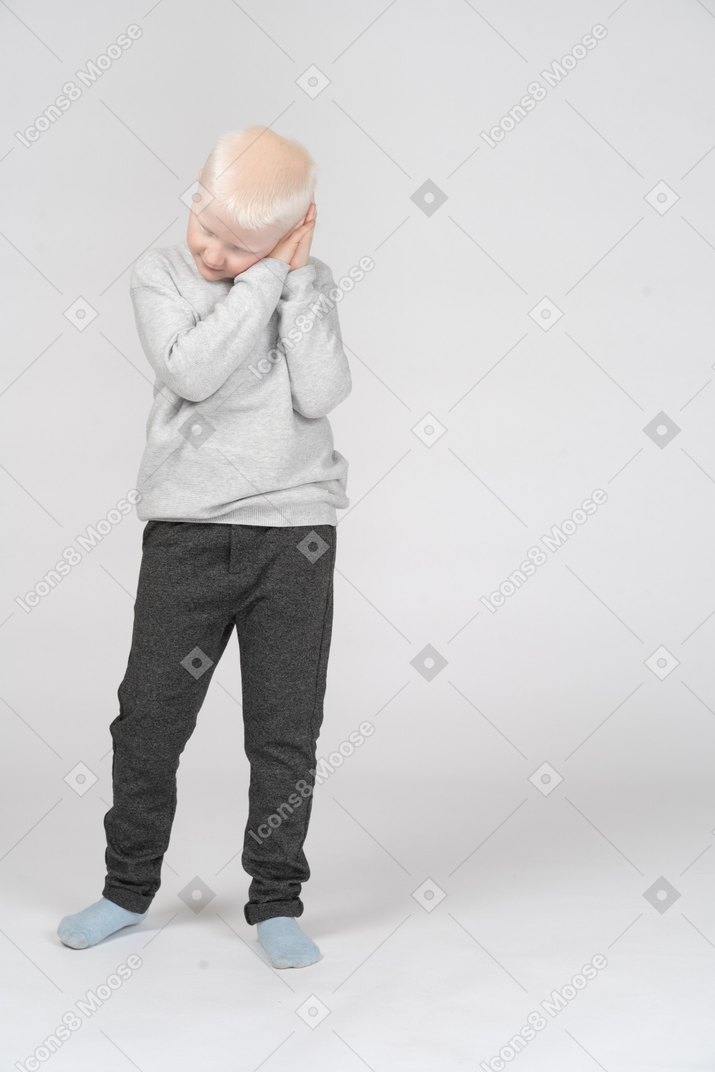 Front view of a boy imitating sleeping