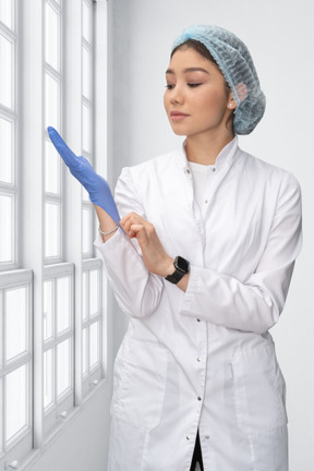A female surgeon putting on a glove