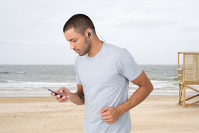 A man standing on a beach with a cell phone