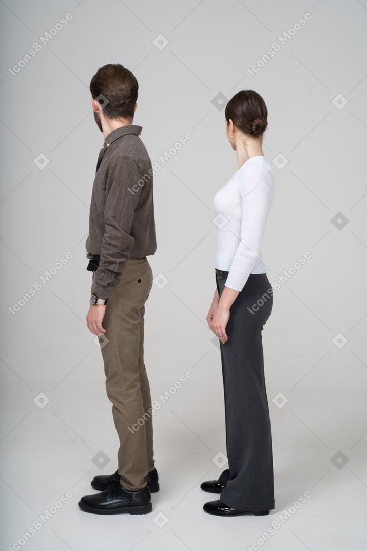 背を向けるオフィス服の若いカップルの側面図