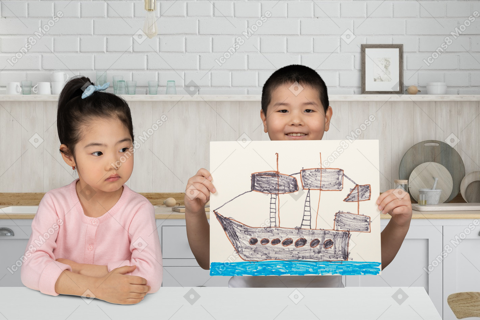A little boy showing a drawing of a ship and sitting next to a little girl