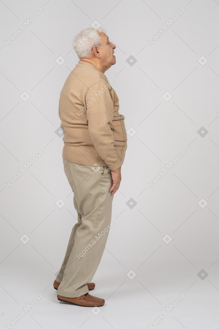Side view of an impressed old man looking up